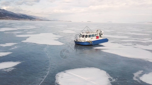 气垫船在平坦的冰雪表面上移动冬季沿冰冻湖山岸移动的救援图片