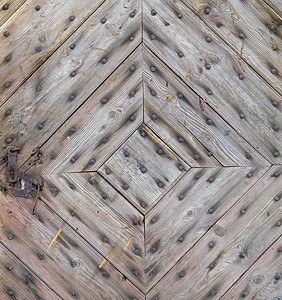 旧乡下房子的门是用对角木板和生锈的钉子制成的图片