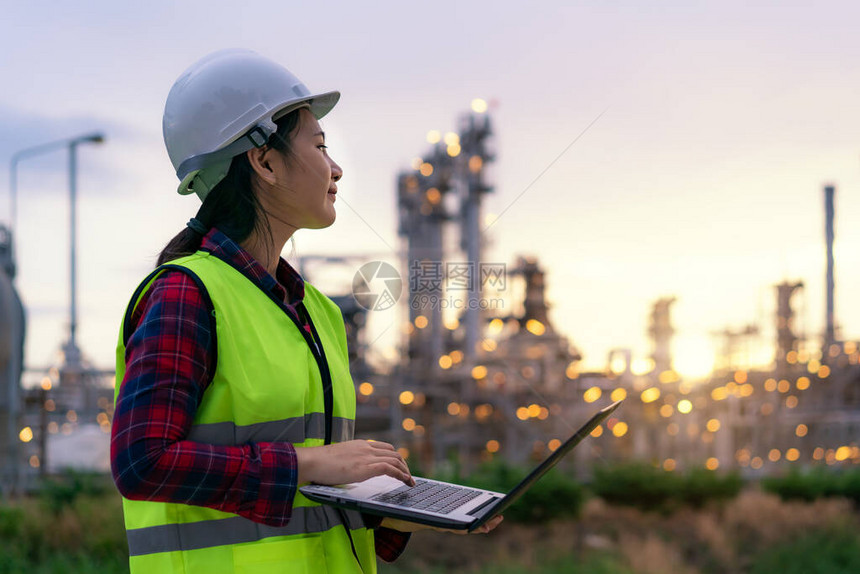 亚洲女石化工程师夜间使用笔记本电脑在石油和天然气炼油厂工业厂内进行检查员图片