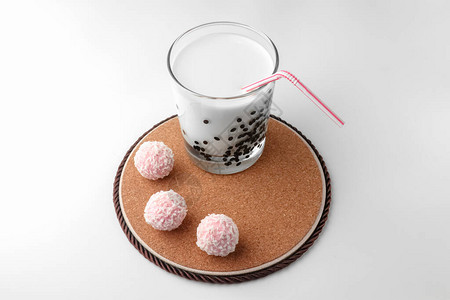 粉红色巧克力糖和一杯白色背景的牛奶图片
