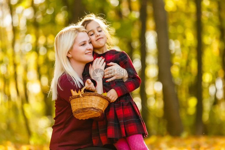 年轻母亲和女儿的小女孩在秋天公图片