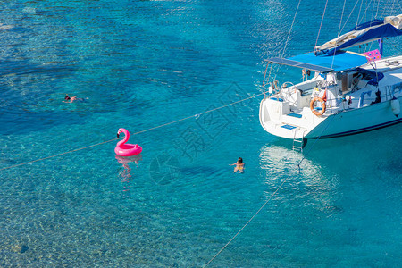帆船停在美丽的蓝水上人们和他们的粉红色火烈图片