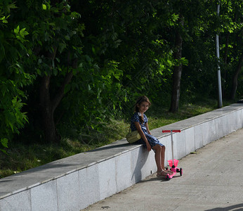 坐在轨道上的长凳上的女孩图片