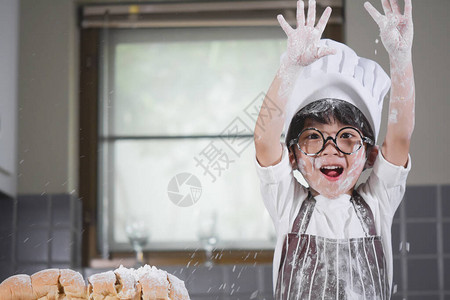 亚洲男孩戴眼镜用白面粉揉面包团教孩子们在厨房里练习烘焙配料面包餐具上的鸡蛋快乐的学习生活与家人背景图片