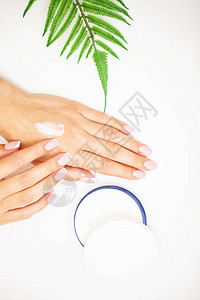 女人特写使用保湿霜进行手部皮肤护理图片