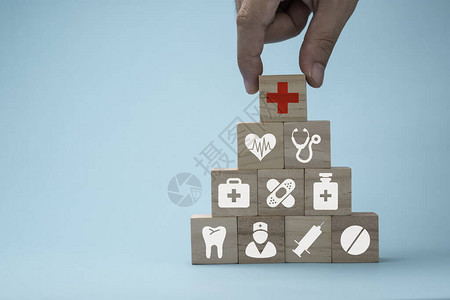 手把木制立方体堆叠在蓝色背景上的医疗保健药物和医院图标医疗保图片