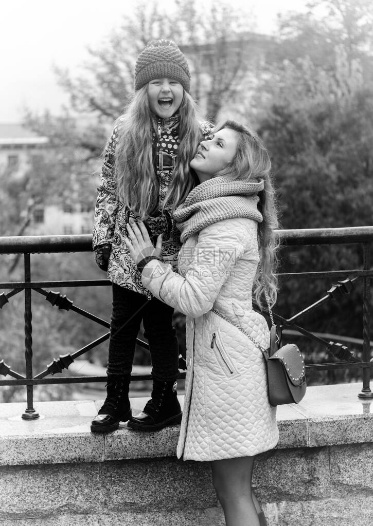 一位年轻的母亲和她的女儿心情愉快地漫步在城市中带孩子的妈图片