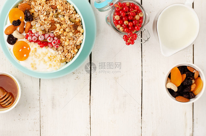 格兰诺拉麦片碗健康早餐与干果坚果和新鲜的红醋栗在白色木背景顶视图片