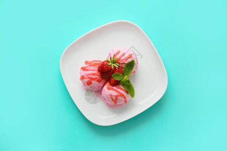 彩色背景中带有美味草莓冰淇淋的盘子图片