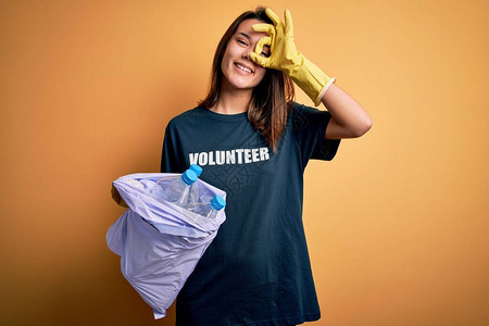 美丽的志愿者女孩关怀环境做志愿者拿着袋子图片