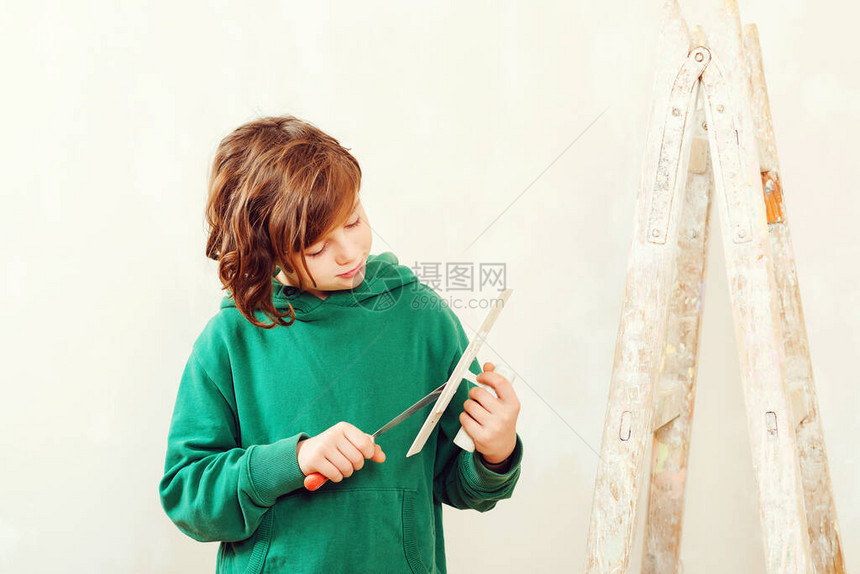 英俊的男孩用抹刀工作装修可爱的儿子帮助父母修理房间带工具的孩子图片