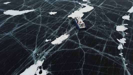 雪空气船在结冰的湖面的大雪场上行驶奥尔洪岛悬崖附近贝加尔湖冰冷图片