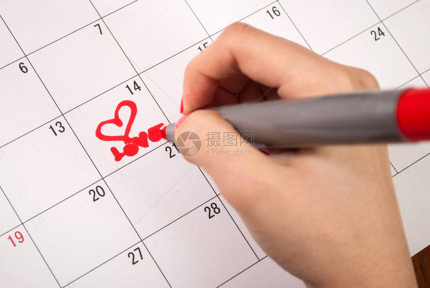在情人节的日历上女人用铅笔手图片