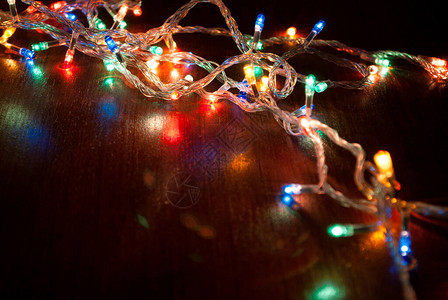 木制桌面上的圣诞彩色灯光Xmas和新年假日概念选择图片