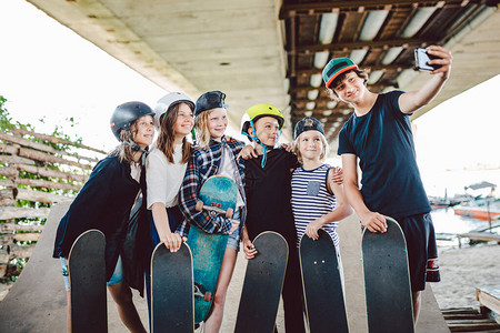 大群朋友儿童滑板运动员在滑板公园制作视频在线广播电话视频通话图片