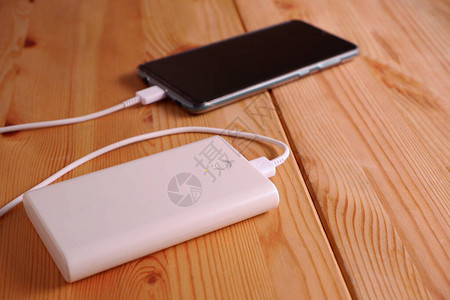 智能手机在桌上的木桌上用备电池图片
