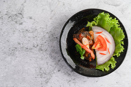 开胃香辣沙丁鱼罐头沙拉黑陶瓷碗中的辣酱图片