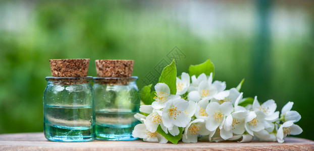 茉莉香油装满茉莉油的瓶子新鲜花和树叶在天图片