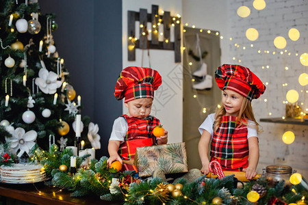 一个戴着厨师帽和围裙的孩子为圣诞节准备饼干面团图片