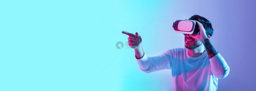 与虚拟世界的熟悉微笑的家伙在蓝和紫外线背景全景复制空间上戴眼图片