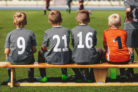 足球队的男孩坐在替补席上准备参加决赛图片