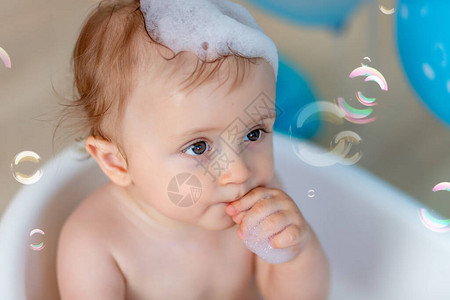 男孩子在浴缸里洗澡的肖像有气球和肥皂泡快乐的童图片