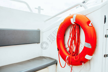 红色救生衣绳挂在一面白色漆白的船边侧图片
