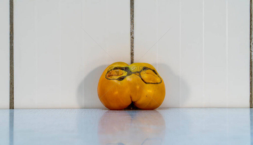 奇怪的黄色番茄作为戴眼镜的人脸图片