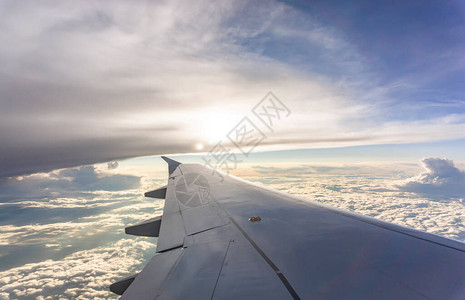 航天员出舱从透明的玻璃窗座位到飞机翼的天空景观背景