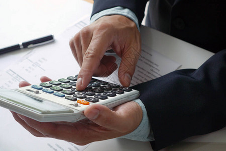 银行工作人员或会计师使用计算器计算和检查账户会计图片