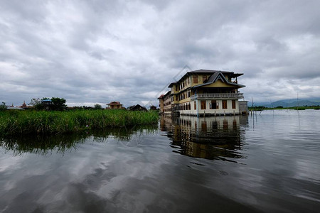 缅甸内尔湖的缅甸岛传统房屋和漂浮绿色植物云天多云图片