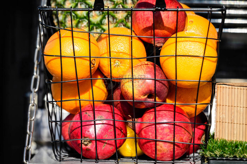 在罗马尼亚布加勒斯特街头食品市场展示供销售的金属篮子中的橙子红苹果和石榴水果图片