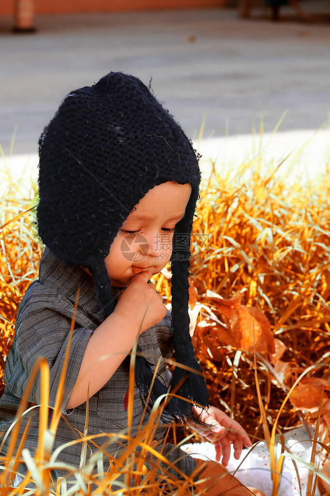 秋季喜悦的甜混合式男孩近距离观看编织帽的可爱甜蜜和图片
