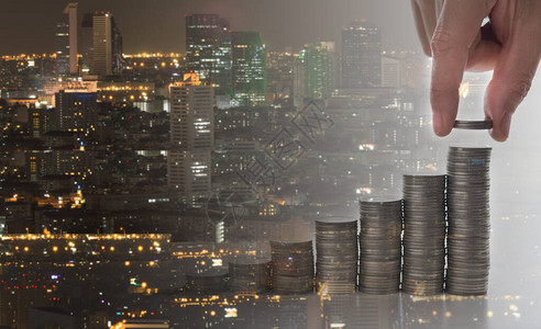 房地产投资房地产基金融理念手把硬币放在具有城市背图片