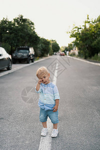 可爱的小男孩在附近路上行走图片