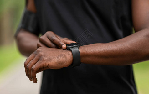 非洲运动员在运动期间检查他的健身手镯图片