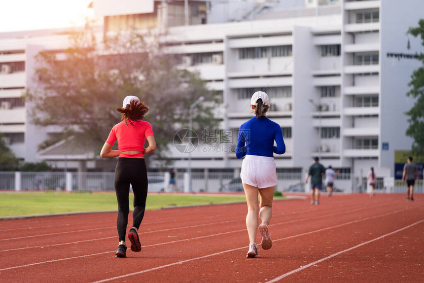 年轻的健身女子赛跑者早上在城市的体育场跑道上慢跑锻炼在COVID19大流行期间图片