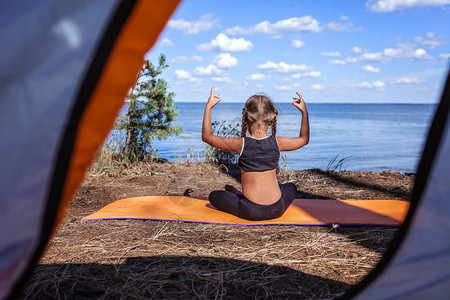 在夏日露见晨操外边露台边露营地做瑜伽的可爱女孩背景图片