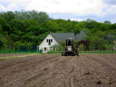 用拖拉机在开阔的乡村自然的棕色土壤中犁过的田地图片