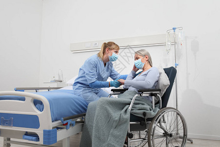 护士安慰坐在轮椅上的老年妇女图片