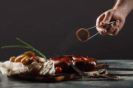 烤自制香肠配小土豆和大葱背景是木板图片