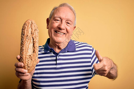 头发灰白的老人拿着健康的全麦面包图片