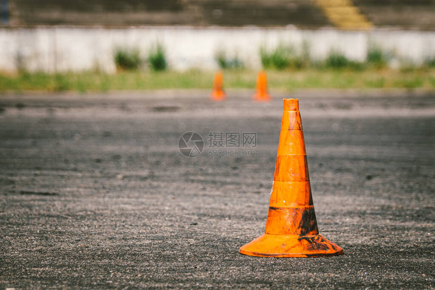 驾驶培训或汽车学校现场旧脏橙色交通锥的特写图片