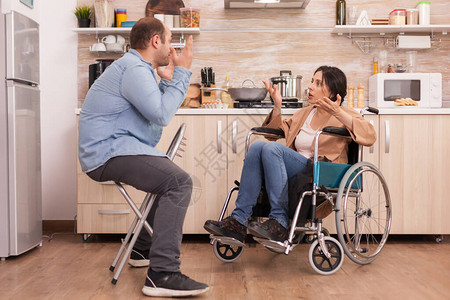 坐在轮椅上的残疾妻子在厨房里对丈夫大喊叫残疾瘫痪残疾妇女在事故后图片