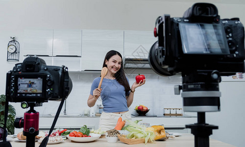 社交媒体概念一个快乐的女人站在里用相机在线录制视频快乐的亚洲女人vlogger直播在线视频教学背景图片