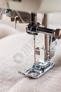 现代缝纫机压脚和针缝制衣服的特写镜头图片