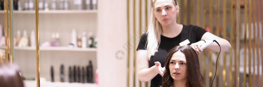 与女客户谈论发型的理发师肖像发型师为黑发做卷发使用卷发器的理发师美容图片
