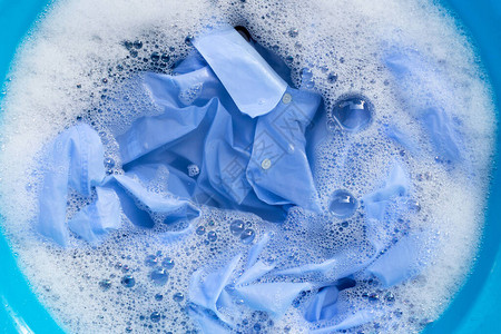 蓝色衬衣在粉末洗涤水溶解中浸图片
