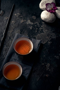 亚洲茶叶仪式瓷器茶杯和深黑石本底的图片