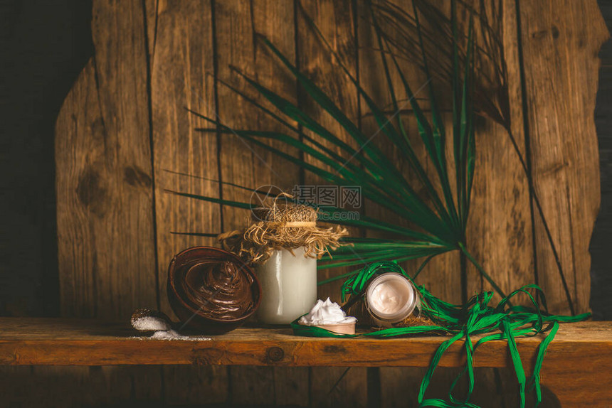 一碗融化的巧克力和椰子油温泉椰子油和巧克力木制背景上的巧克力和图片